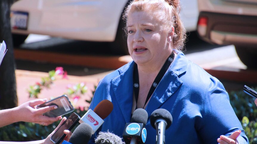 A mid shot of WA Education Minister Sue Ellery speaking into microphones outside Parliament House in Perth wearing a blue top.