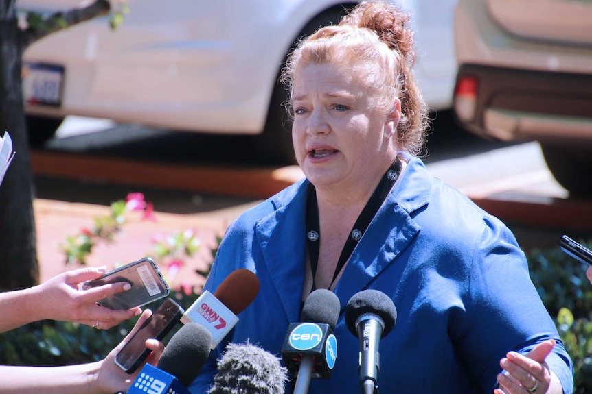 A mid shot of WA Education Minister Sue Ellery speaking into microphones outside Parliament House in Perth wearing a blue top.