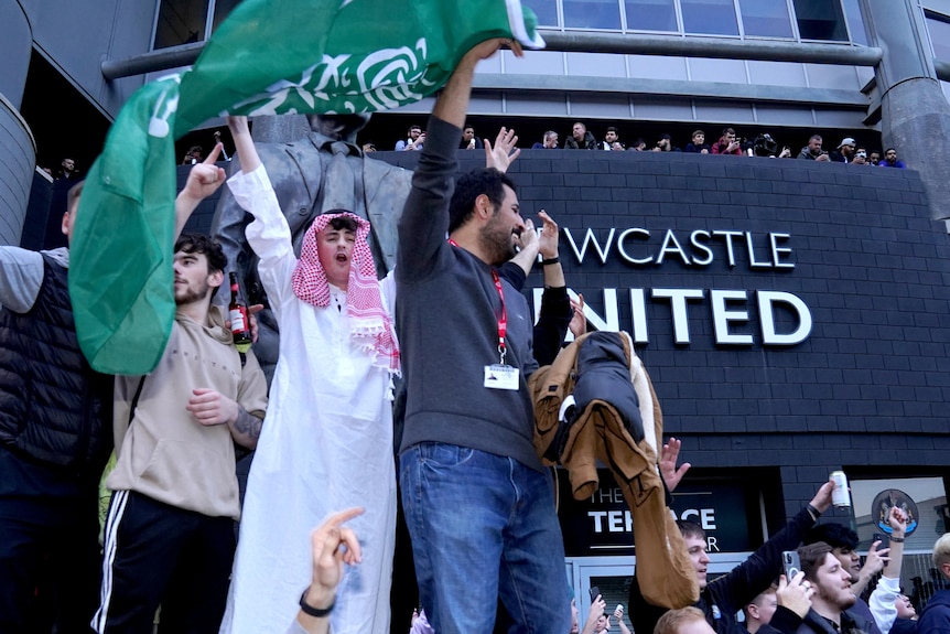 Newcastle supporters wave a green Saudi Arabia flag outside St James' Park