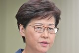 Carrie Lam speaks into the microphone at the press conference.