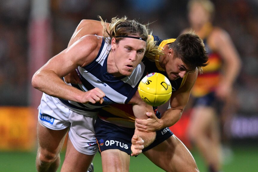 Mark Blicavs gets a hand pass away as he is tackled by Riley Knight.