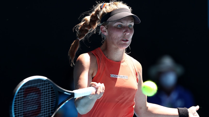 An Australian female tennis player hits a forehand.