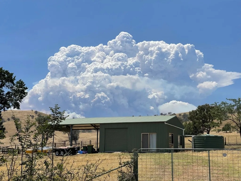 Se forma una nube sobre un incendio sobre una colina.