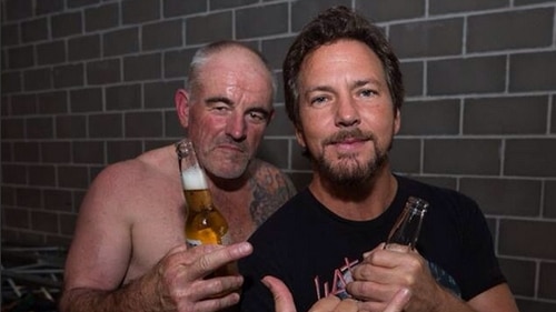 Ross Knight, shirtless, and Eddie Vedder hold beers while looking at the camera