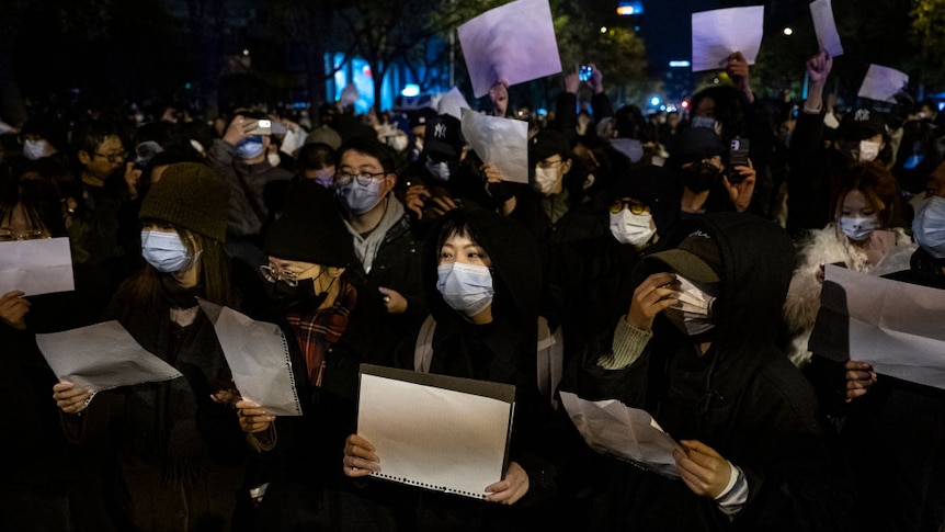 Young Chinese protestors holding up blank pieces of paper