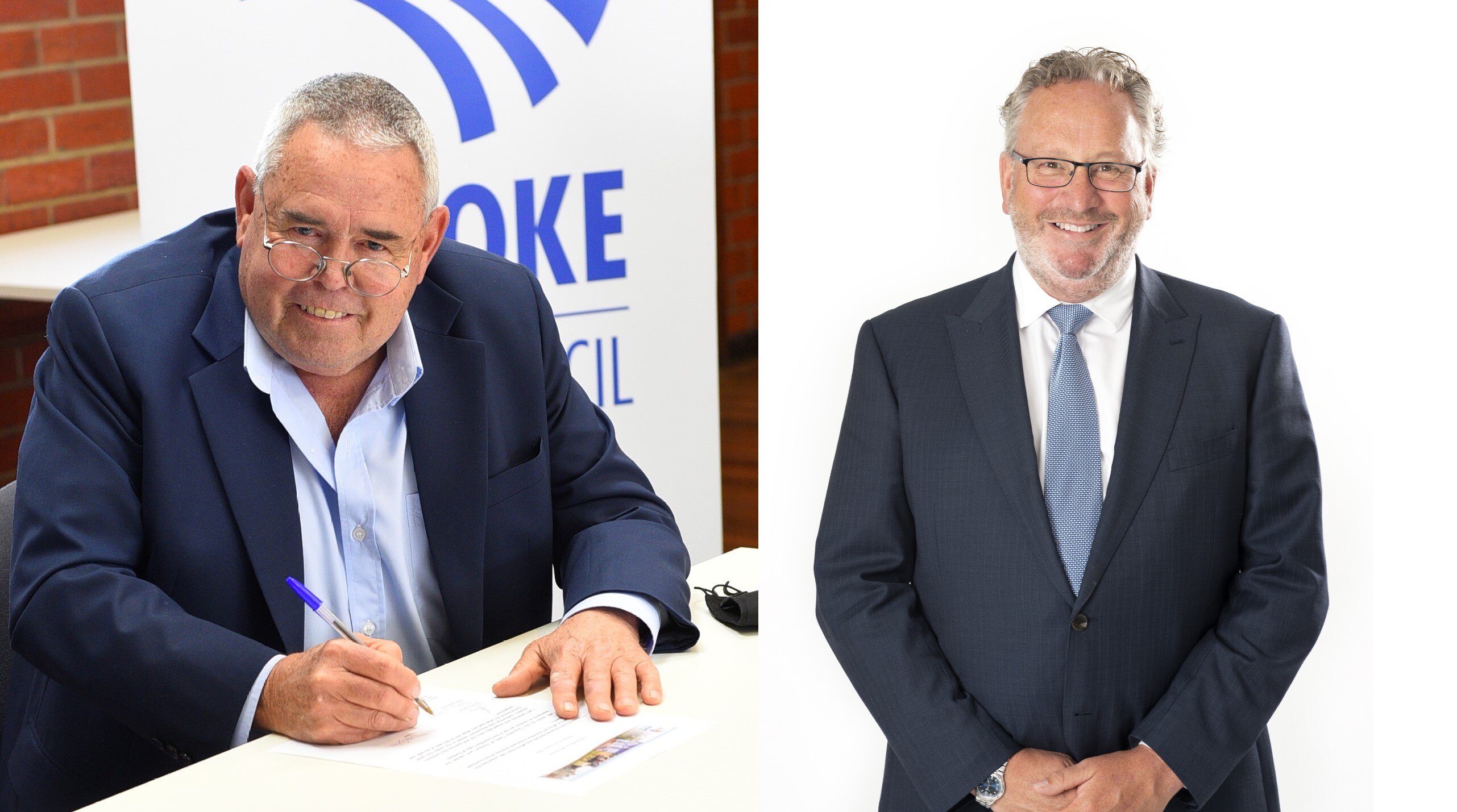A composite image of two men in blue suits, one sitting signing a form, the other standing.