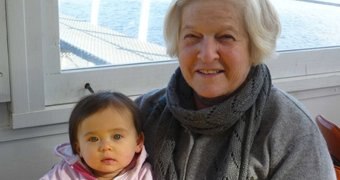 A woman holds her granddaughter on her lap.