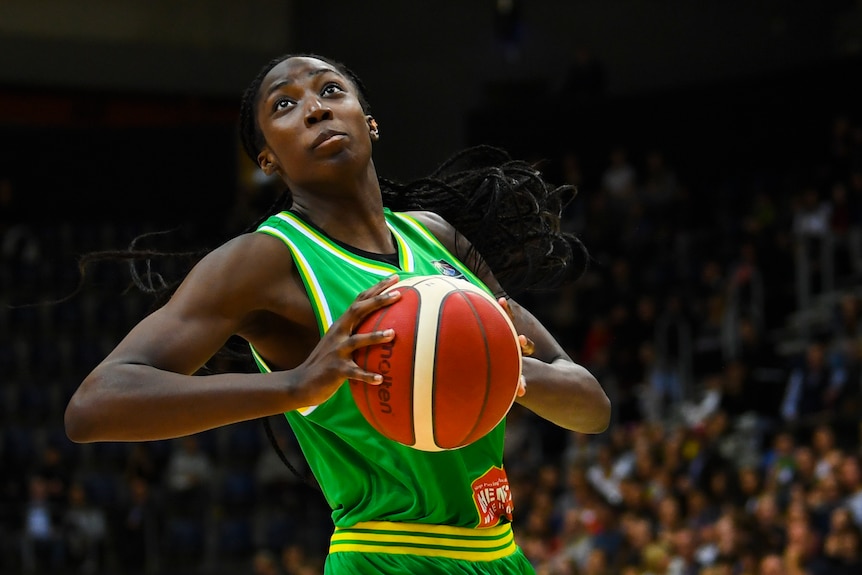 An Australian Opals basketballer holds the ball in both hands against China.