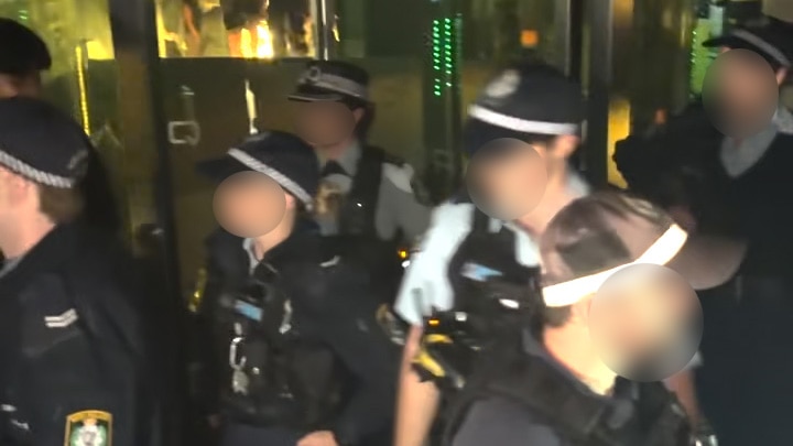 several police officers inside a darkened nightclub