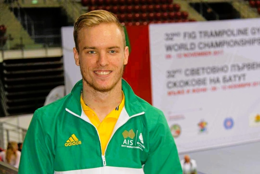 A man wearing a green and gold sporting team tracksuit.