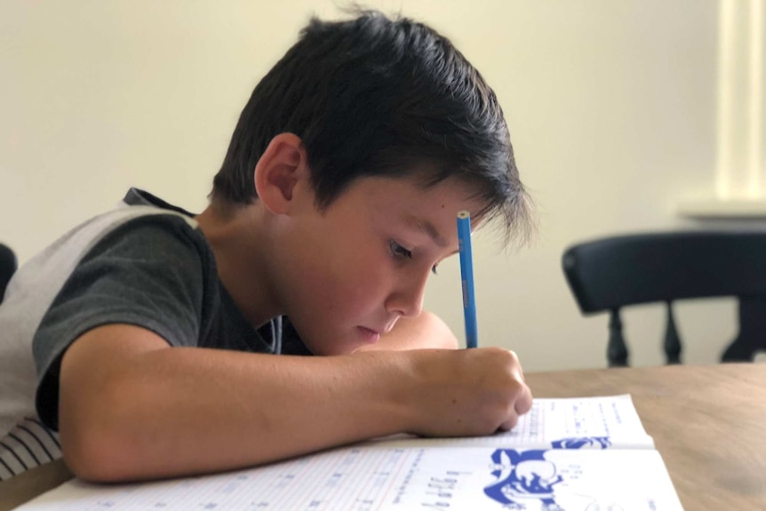 Lochie House works on his school work at home