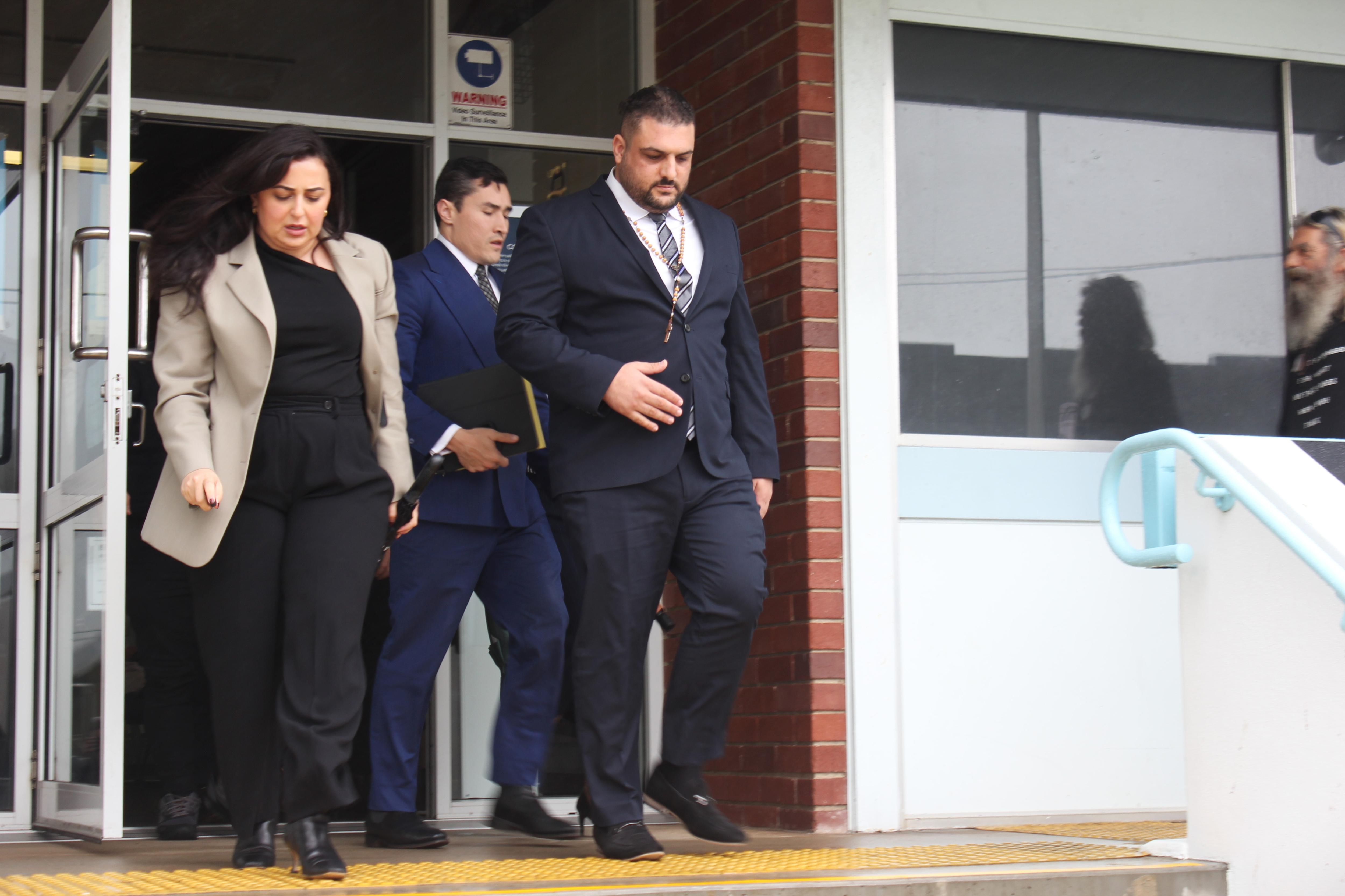 Male and female dressed in professional clothes leaving the courthouse. 