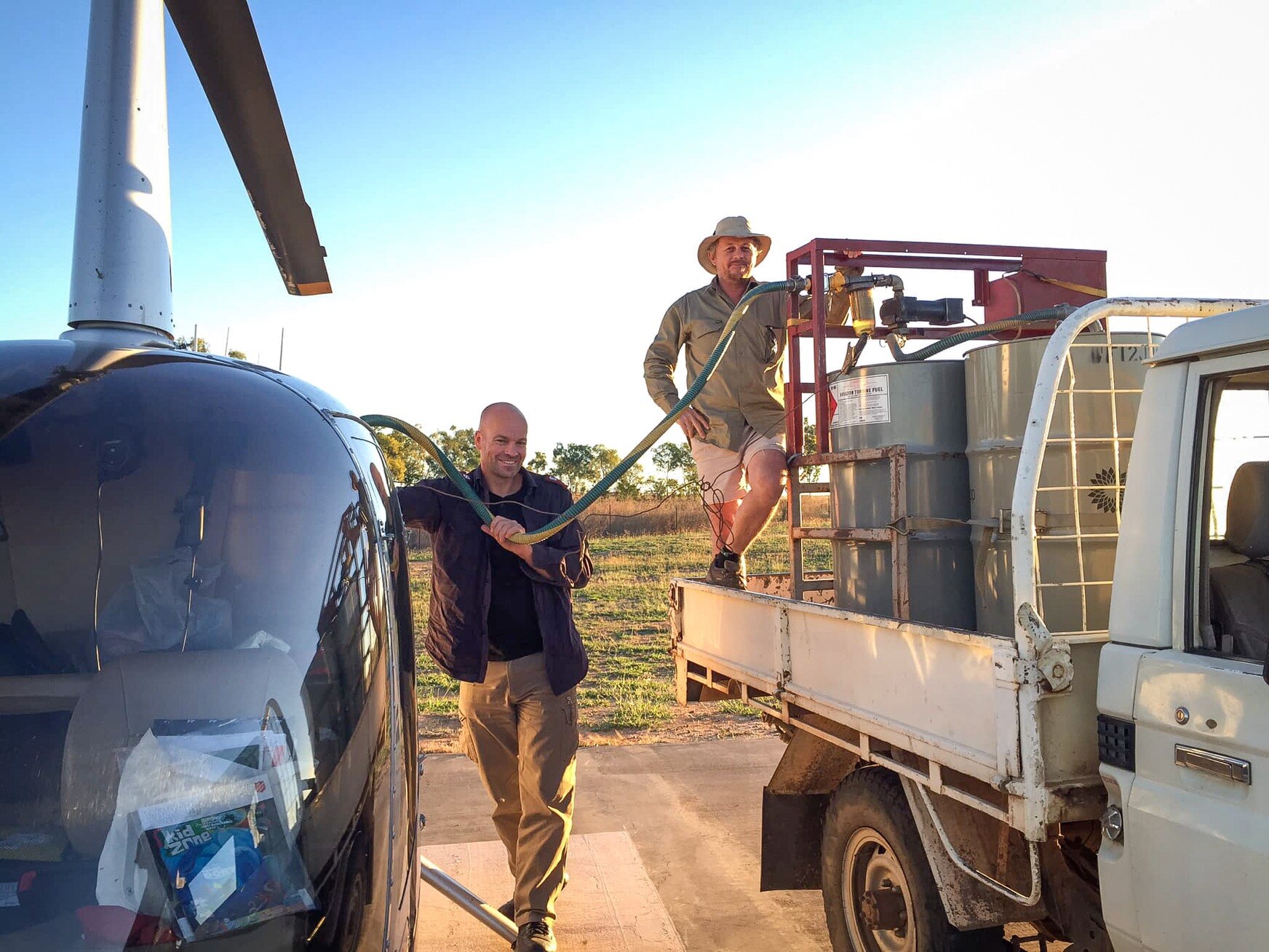two men refuel a helicopter