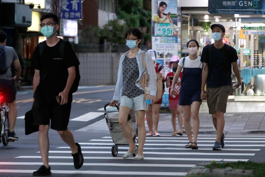 人们戴着口罩走在台北街头