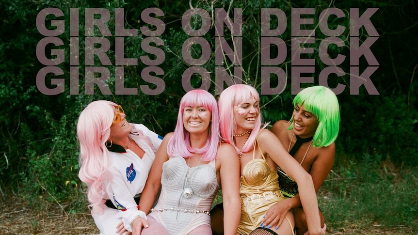 Four girls in multicoloured bob wigs set in grass smiling. They wear colourful leotards & glitter.