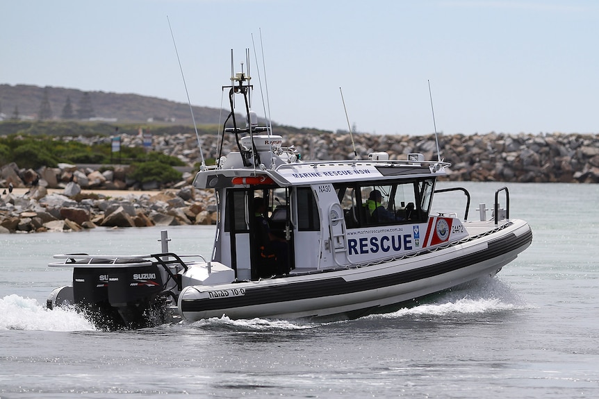 A marine rescue boat with colunteers inside in the water driving toward the ocean in Narooma. 
