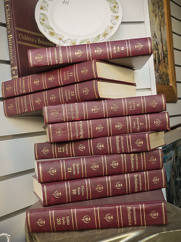 Encyclopedias being used as a display in an op shop.
