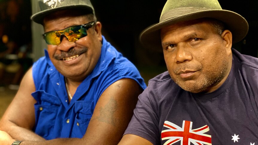 Two men from the Solomon Islands sitting side by side, smiling.