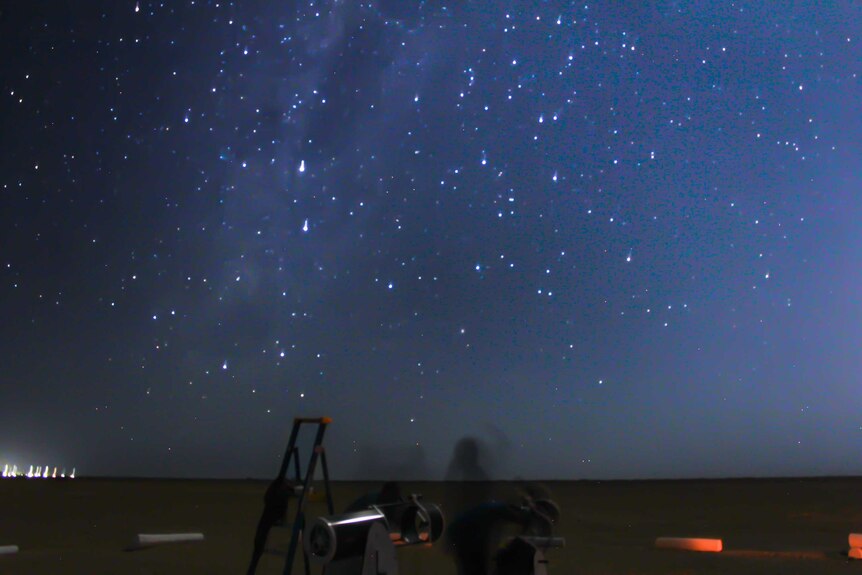 A blue star-filled sky with a ladder and telescopes in the foreground.