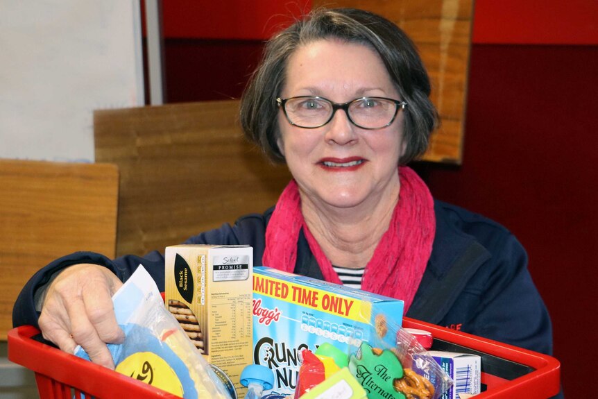 Anglicare manager Kaye Pritchard with a basket of groceries