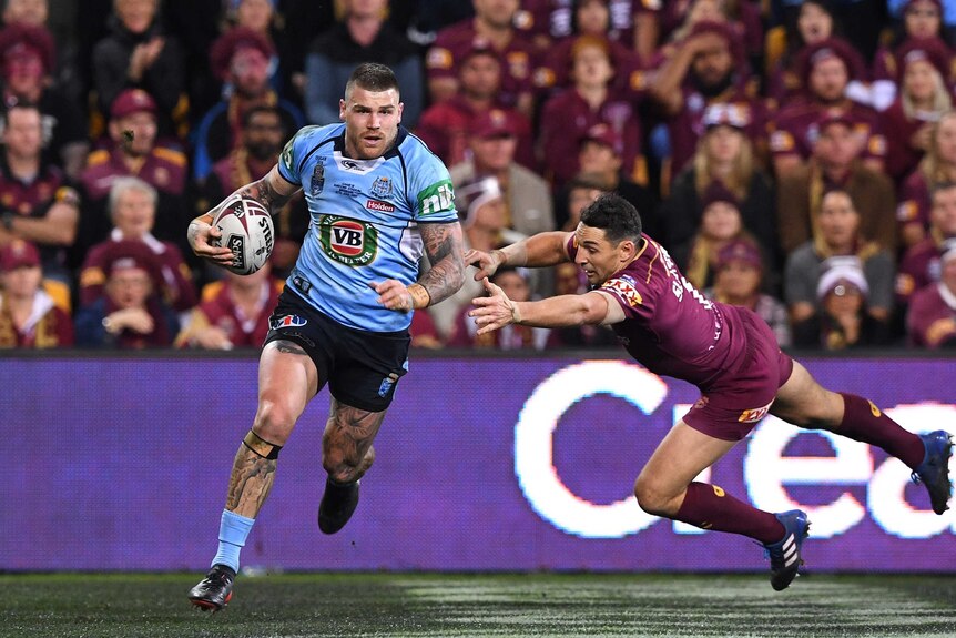 Josh Dugan of the NSW Blues gets past Maroons player Billy Slater to score.