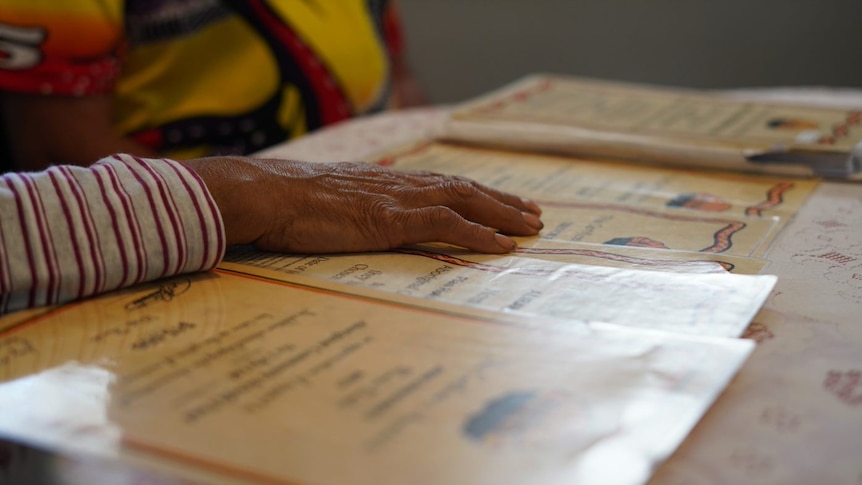 Beverley's hand on a number of ACBF policy certificates.