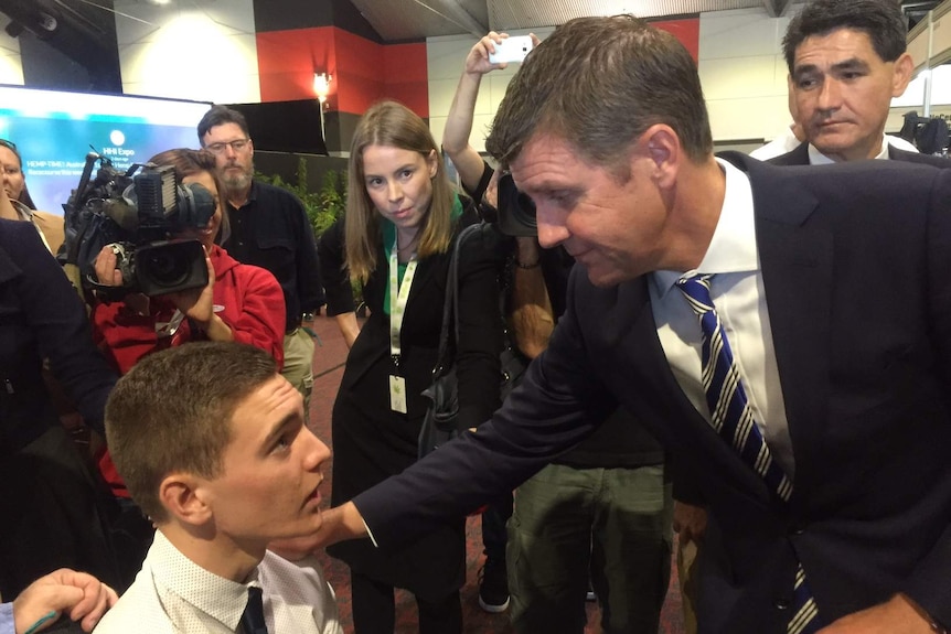 Mike Baird puts his hand on the shoulder of a man in a wheelchair.