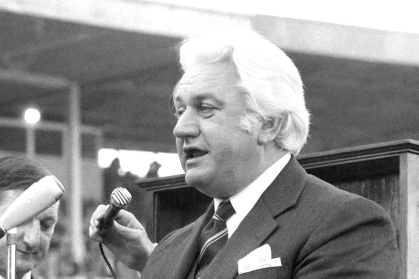 Sir John Kerr speaks in front of a microphone in the middle of the SCG during the 1974 NSWRL Grand Final.