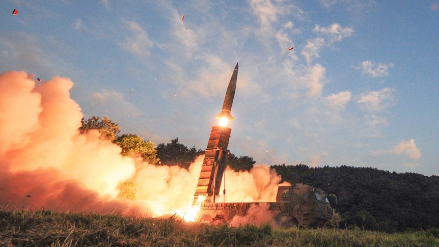 South Korea test fires Hyunmoo II ballistic missile fires from truck painted in camouflage with smoke and fire at the rear