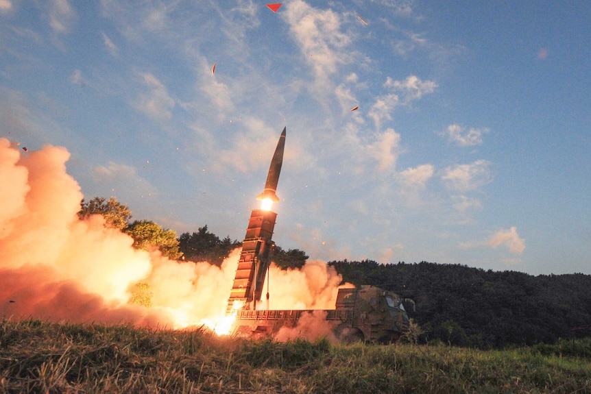 South Korea test fires Hyunmoo II ballistic missile fires from truck painted in camouflage with smoke and fire at the rear