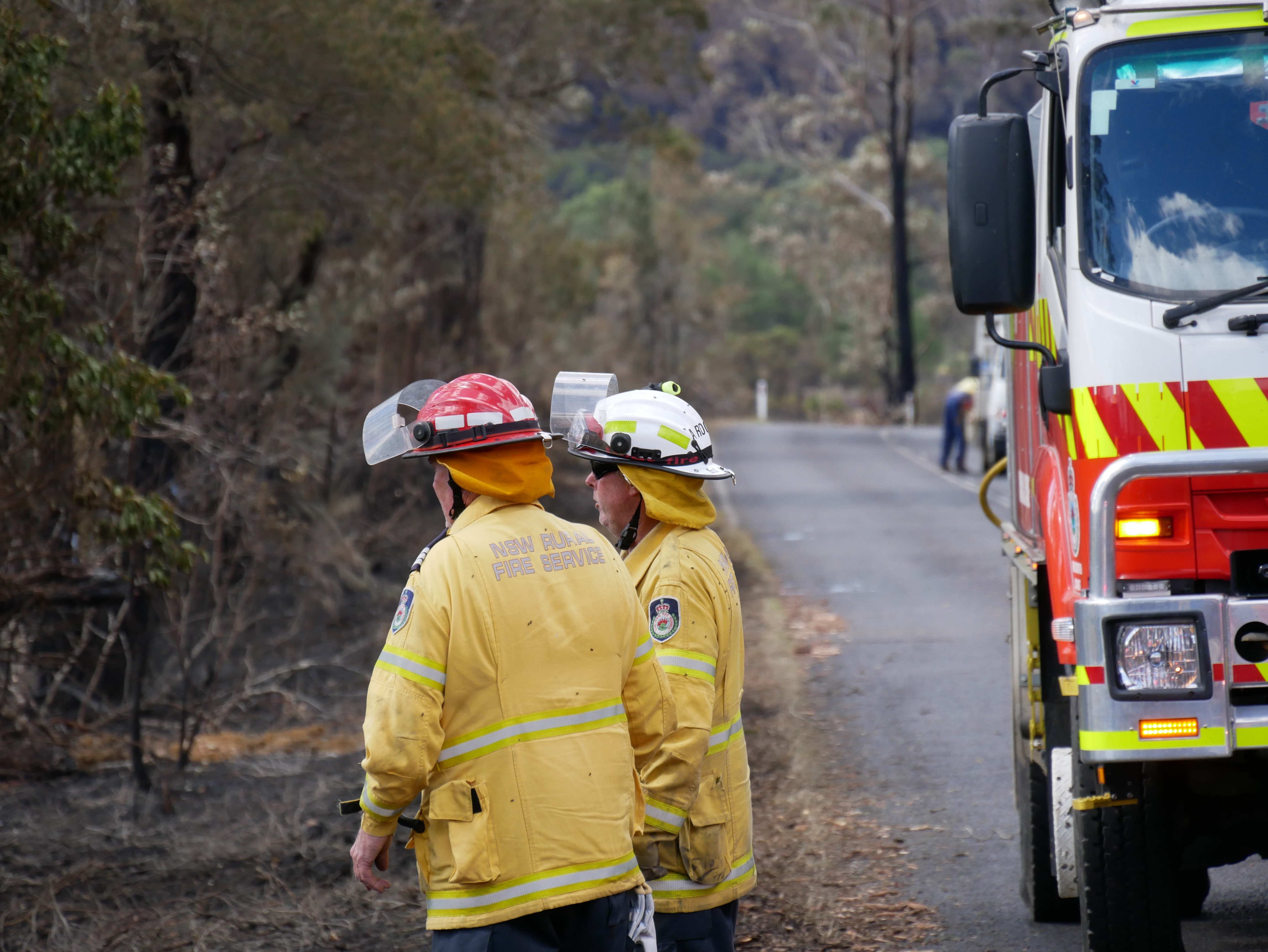 two firefighters looking at burnt ground