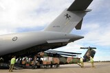 RAAF personnel load one of two Black Hawk helicopters onto a C17 Globemaster