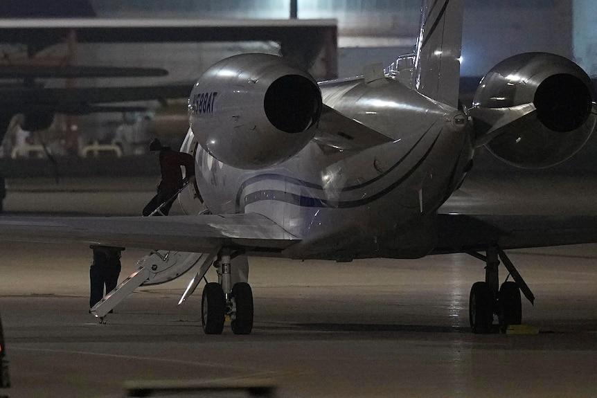 Brittney Griner seen descending plane stairs onto tarmac.