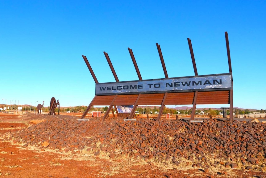 A roadside sign welcoming people to a town.