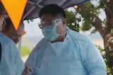 Dr Alvin Chua in his outdoor clinic wearing protective mask, glasses and gown.