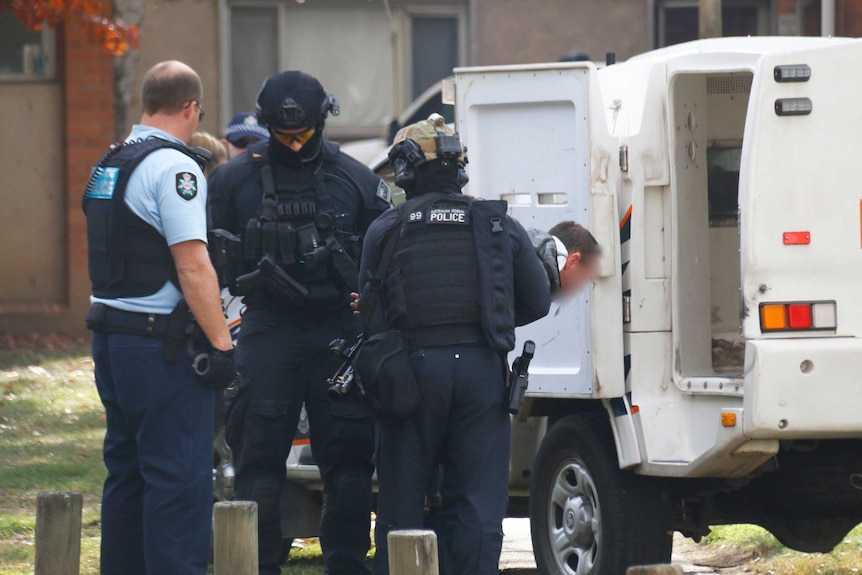 ACT police arrest a man outside a public housing block on Northbourne Avenue.