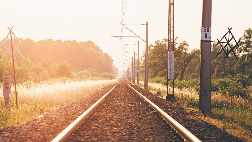 A train approaches at sunset.