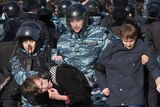 Police detain and march protesters away in downtown Moscow.