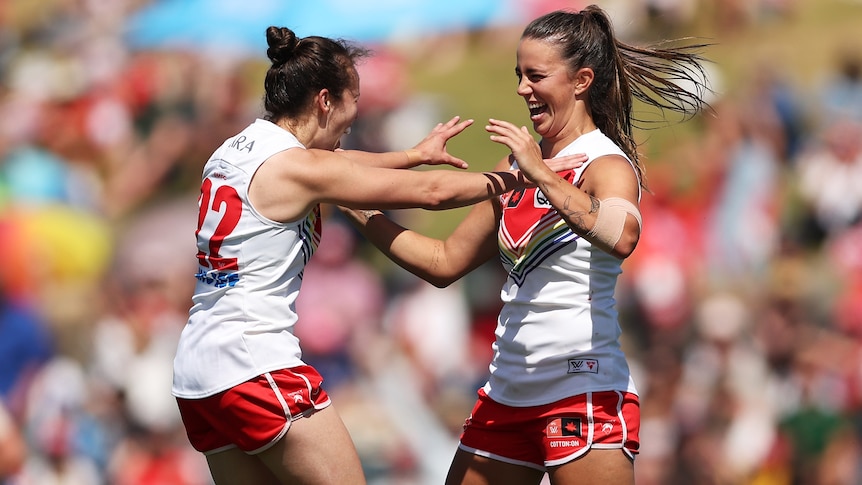 Chloe Molloy of the Swans celebrates with team mates after kicking a goal during the round nine