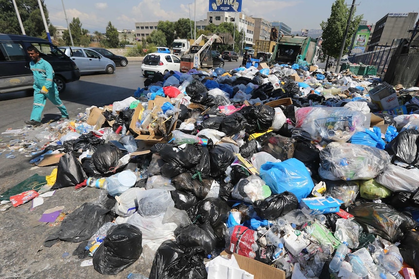 Garbage collectors remove waste from a street in Beirut's east