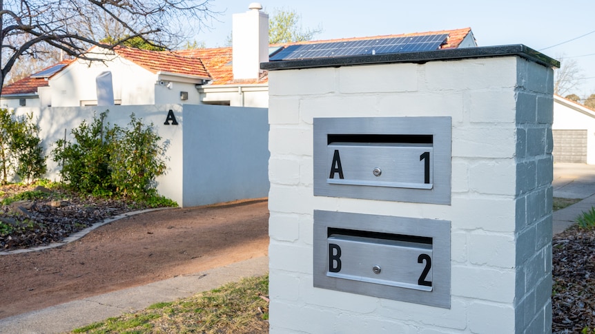 A dual occupancy home with a white mailbox that has two openings that read "A" and "B".