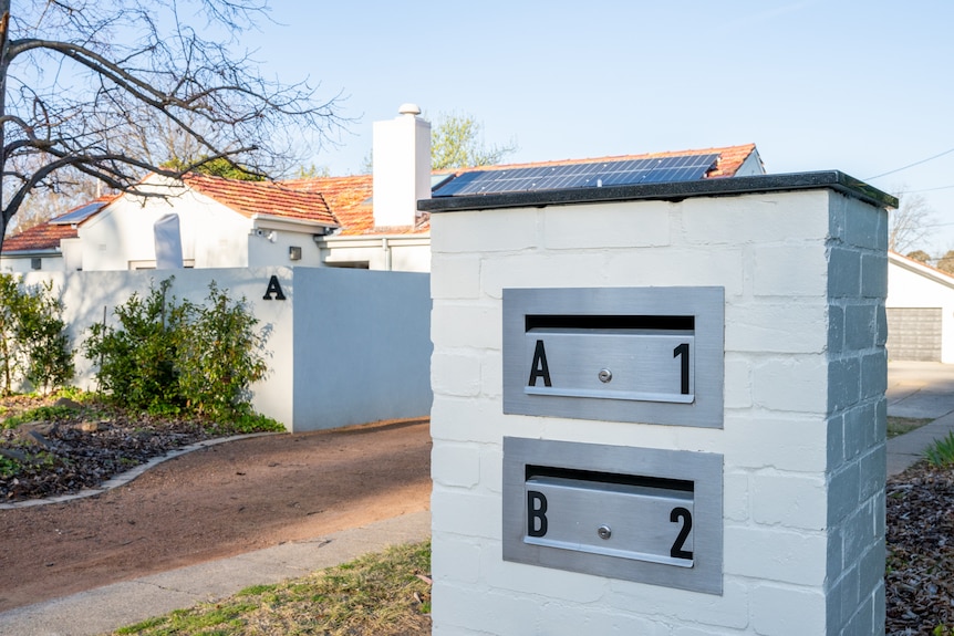 A dual occupancy home with a white mailbox that has two openings that read "A" and "B".