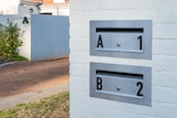 A dual occupancy home with a white mailbox that has two openings that read "A" and "B".