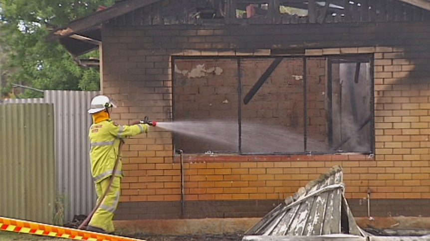 A firefighter sprays water into the house