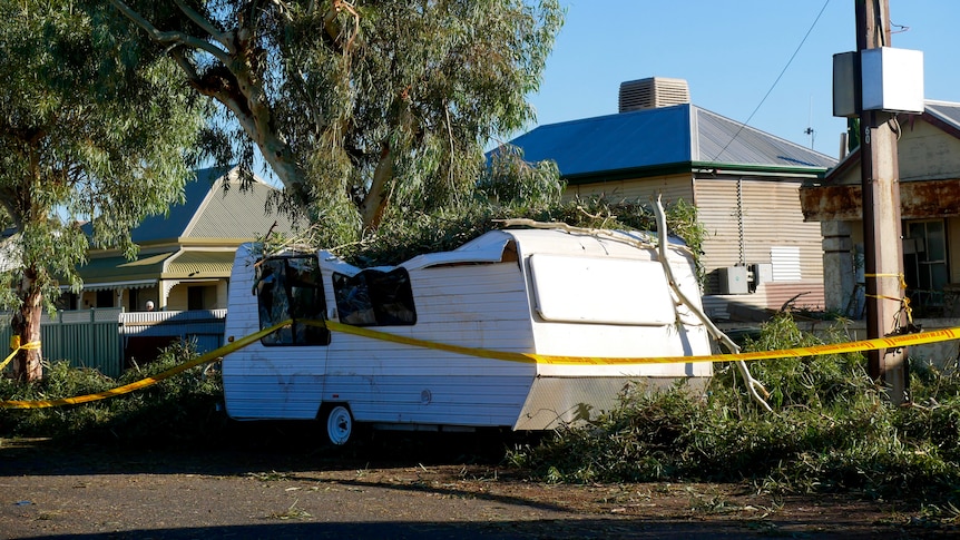 A white caravan crushed by falling trees in Broken Hill. 