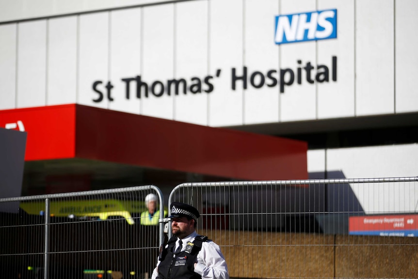 A police officer stands outside a hospital building