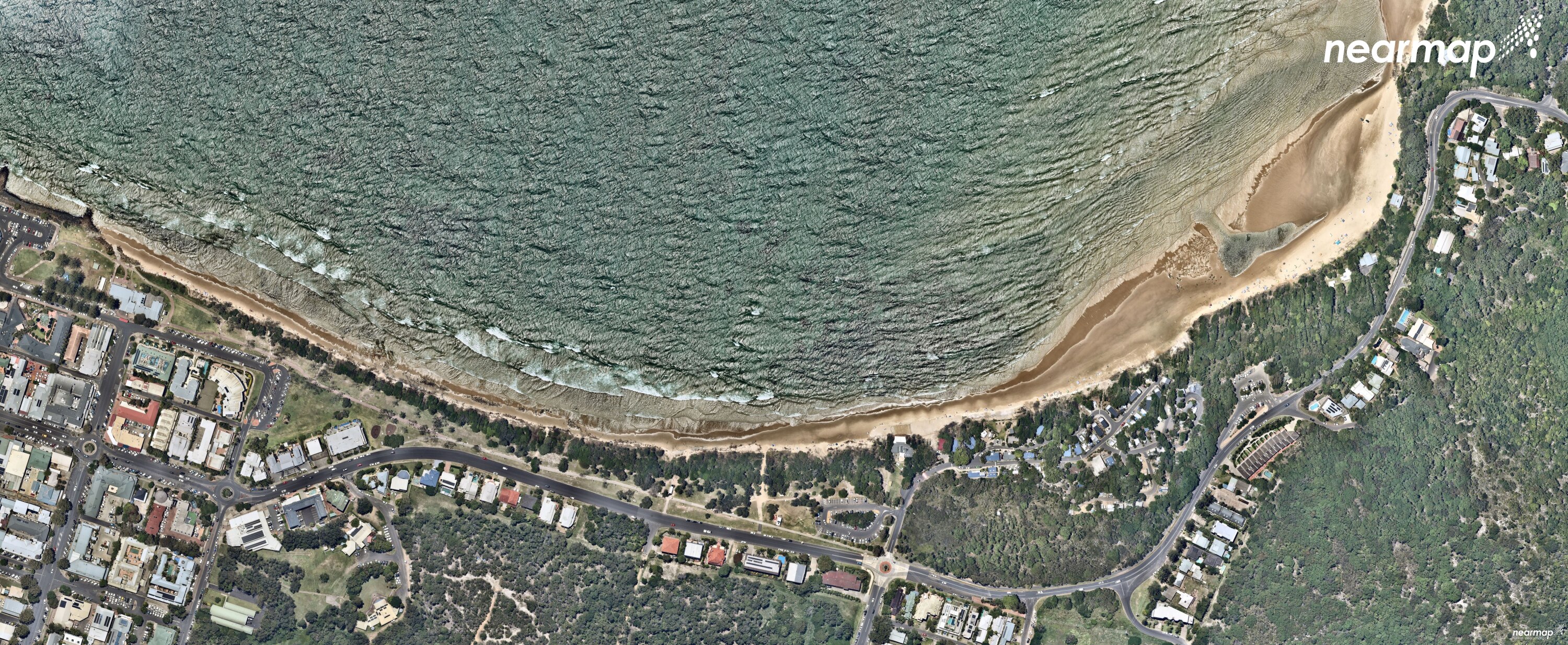 An aerial image of the main beach and Clarkes Beach at Byron Bay shows higher water tides and less sand along the beach.