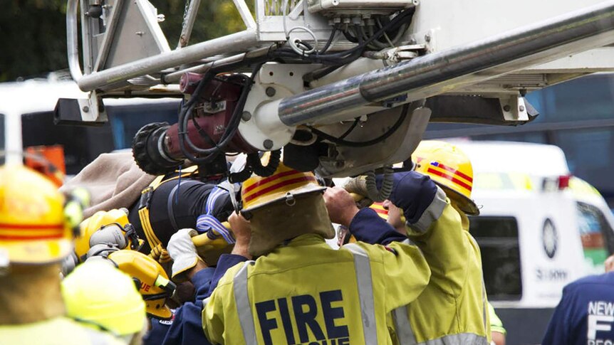 Rescue workers carry a woman survivor after she was rescued from the ruins of a collapsed building in central Christchurch.