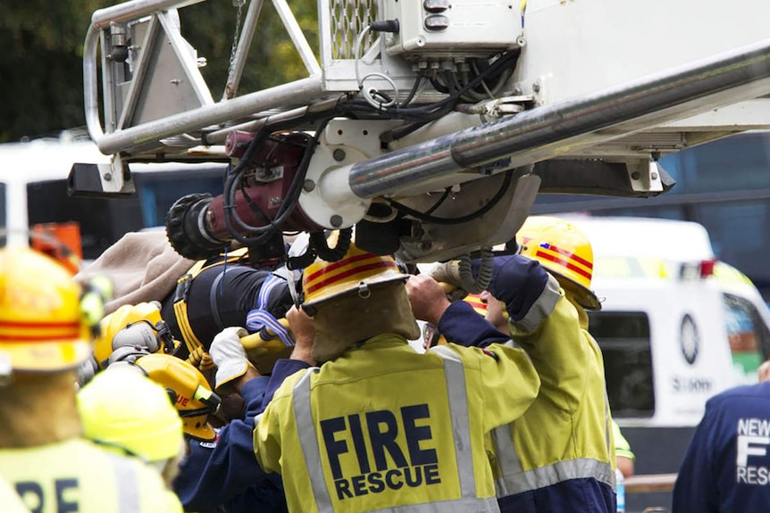 Rescue workers carry a woman survivor after she was rescued from the ruins of a collapsed building in central Christchurch.