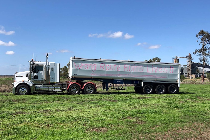 Semi-trailer with words 'wrong route ruins lives' painted on the side.